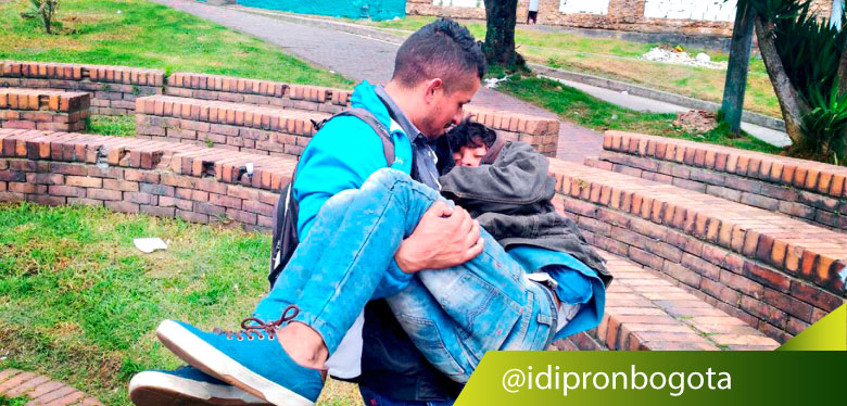 Jóven de IDIPRON lleva en brazo a jóven habitante de calle